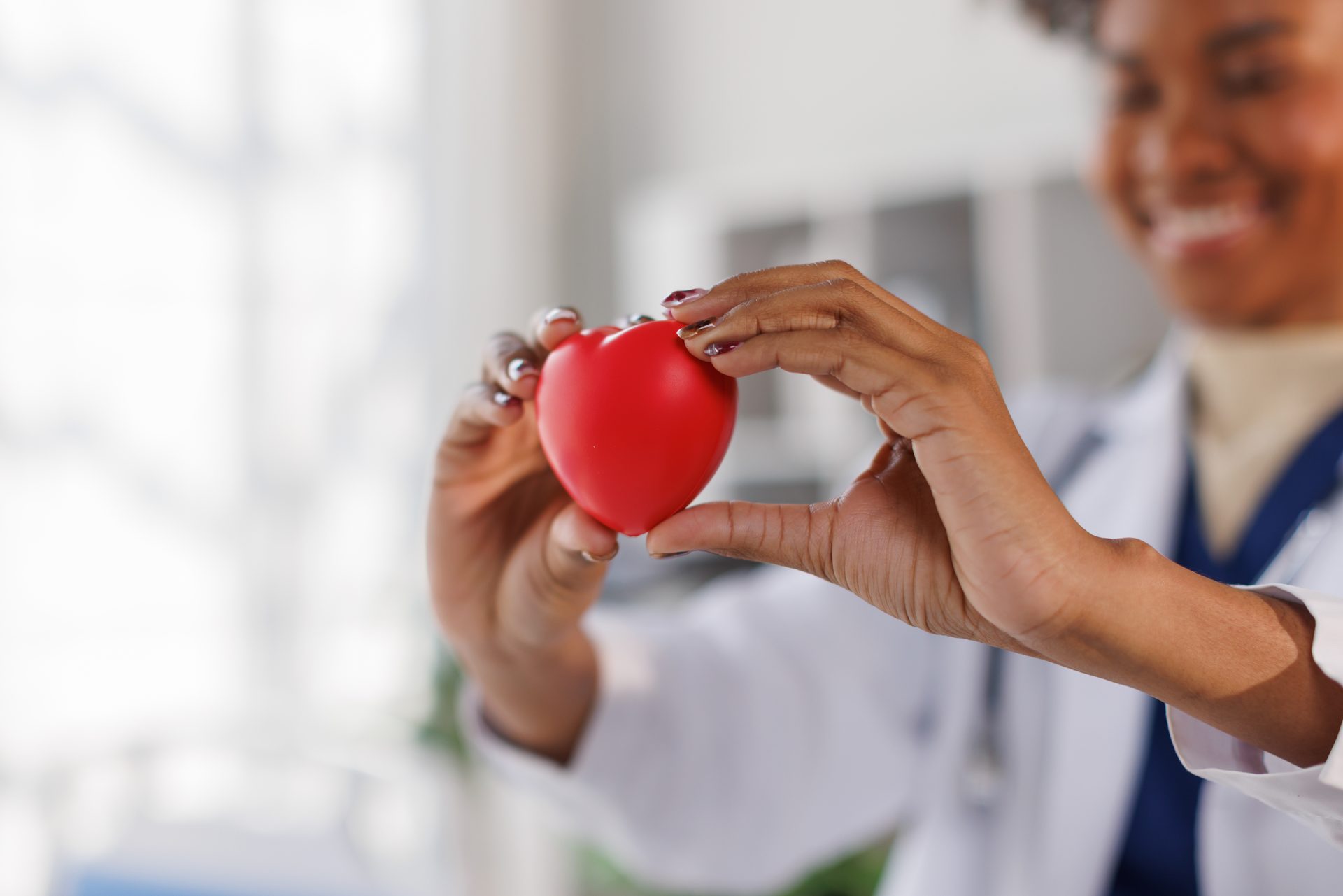 A smiling Arrow clinician holding a heart