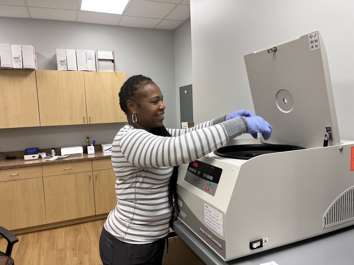 Arrow Clinical Trials team member operating a centrifuge in the Daytona Beach lab